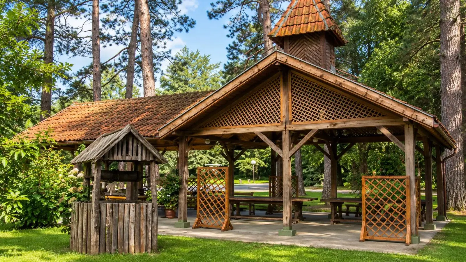 A timber pavilion and a wooden well among pine trees